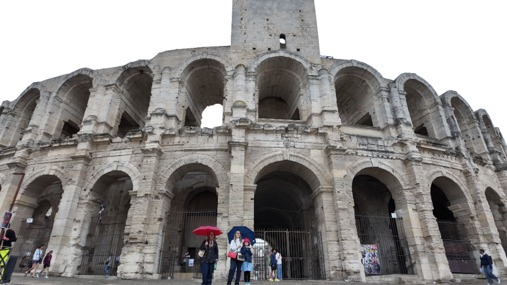 Anfiteatro romano de Arles, com turistas na entrada e os arcos de pedra do século I