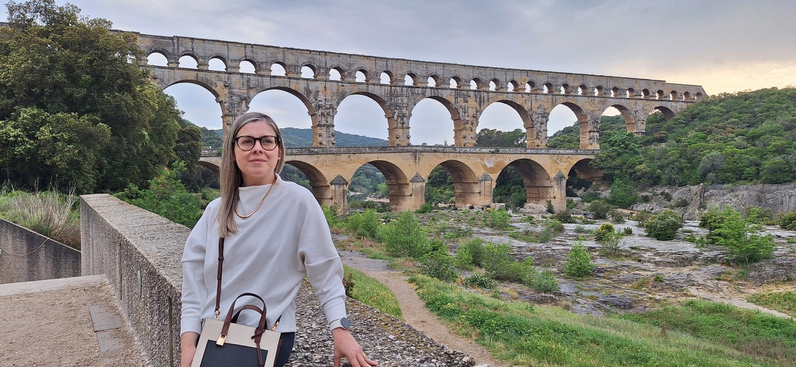 Mulher em frente ao aqueduto romano do Pont du Gard, próximo a Arles