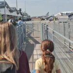 ETIAS para brasileiros: mãe e filha com mochila a caminho do avião no aeroporto